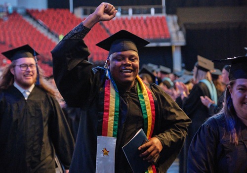 SCC student raises fist after graduating in May 2023. 