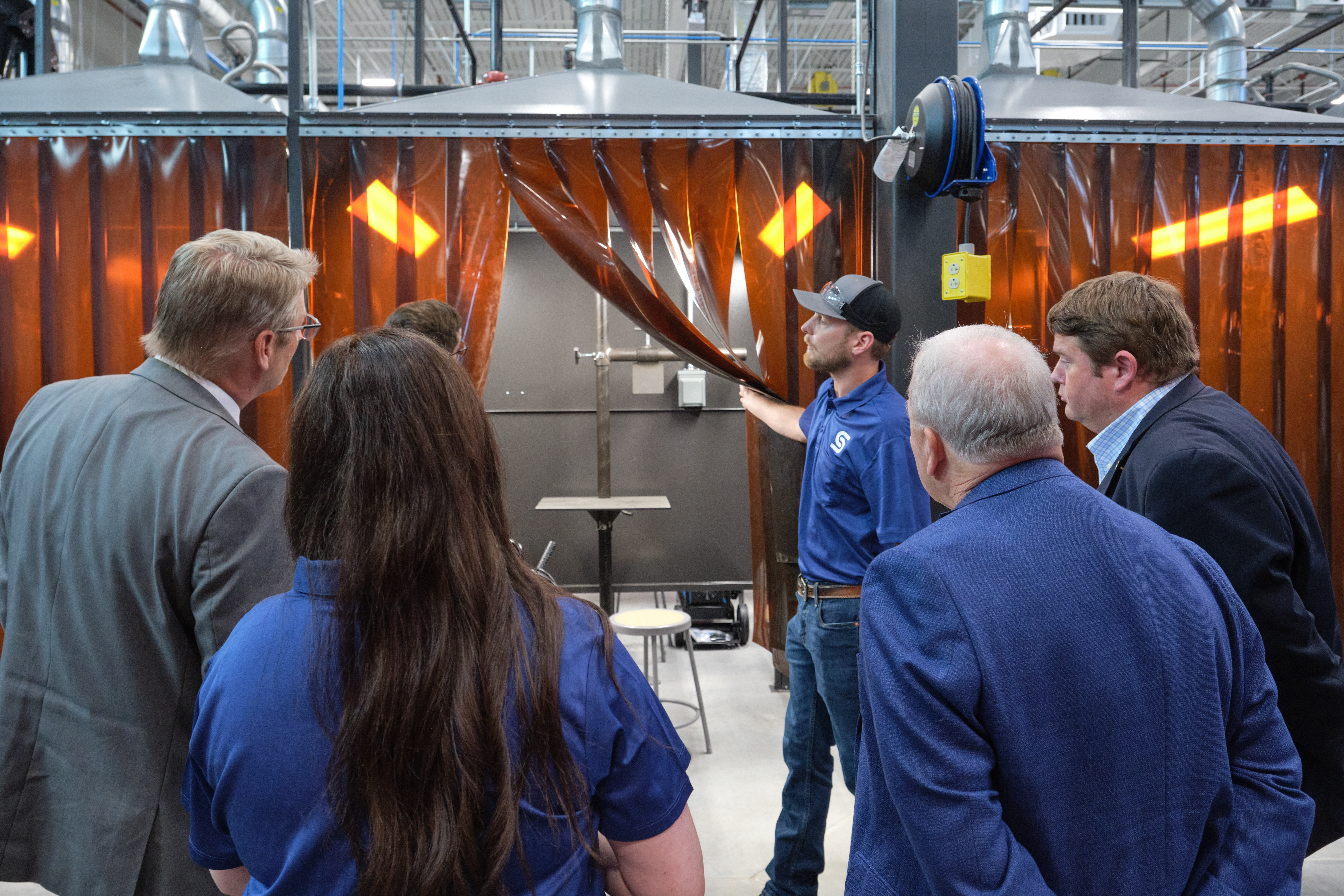 Guests get a first look inside one of the advanced welding booths as the curtain is pulled back during the grand opening celebration Guests get a first look inside one of the advanced welding booths as the curtain is pulled back during the grand opening celebration