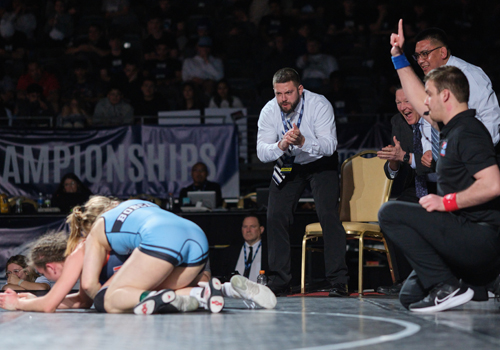 Bobcat wrestling coaches cheer for Eve Herlyn in the 143 pound gold medal match at the NJCAA Championships.